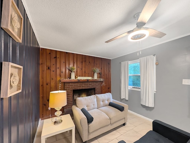 living room with a textured ceiling, a brick fireplace, wooden walls, and crown molding