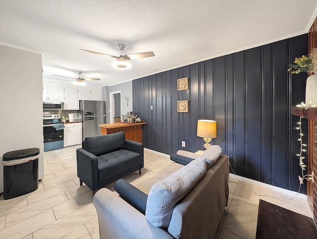 tiled living room with a textured ceiling, ceiling fan, wood walls, and crown molding