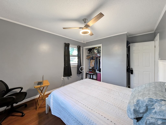 bedroom featuring ceiling fan, crown molding, wood-type flooring, a textured ceiling, and a closet