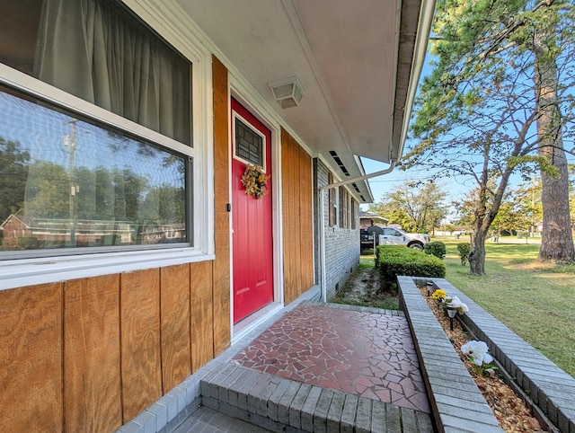 view of exterior entry featuring a yard