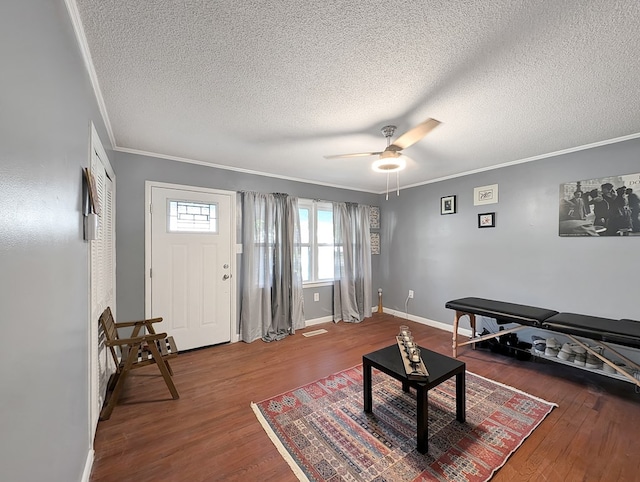 living room with crown molding, hardwood / wood-style floors, ceiling fan, and a textured ceiling