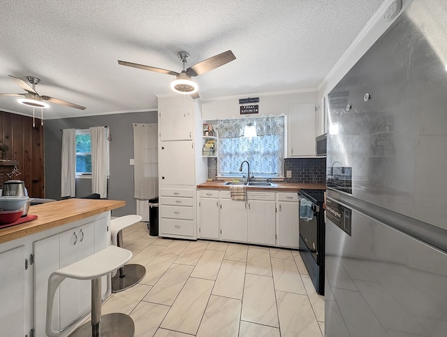 kitchen with white cabinets, stainless steel appliances, tasteful backsplash, and a healthy amount of sunlight