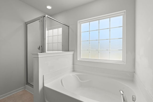 bathroom with a healthy amount of sunlight, plus walk in shower, and tile patterned flooring