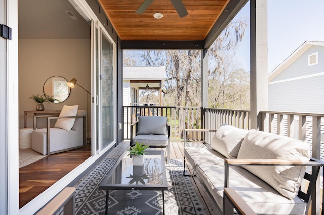 sunroom / solarium featuring visible vents, wooden ceiling, and a ceiling fan