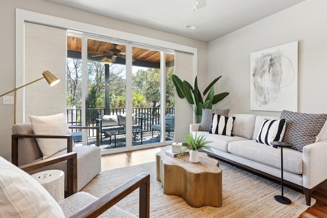 living area featuring visible vents, wood finished floors, and ceiling fan