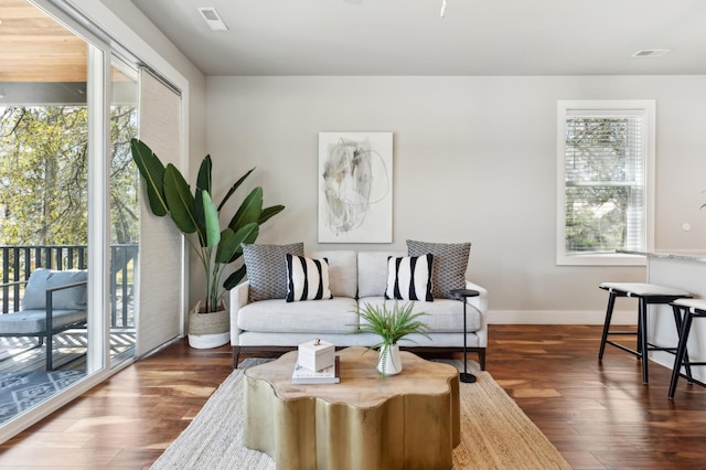 sitting room with visible vents, baseboards, a healthy amount of sunlight, and wood finished floors