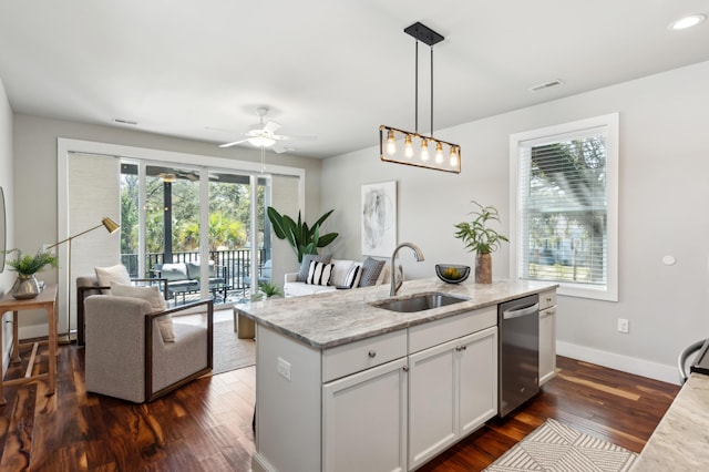 kitchen featuring stainless steel dishwasher, light stone counters, dark wood-style flooring, and a sink