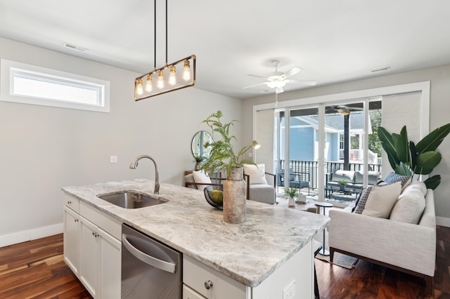 kitchen with dark wood finished floors, a sink, white cabinets, stainless steel dishwasher, and open floor plan