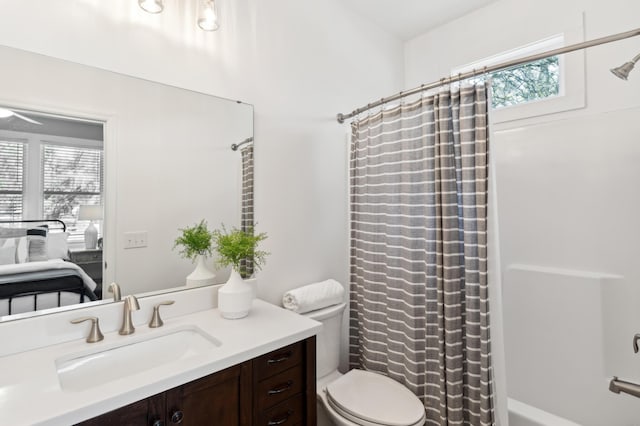 ensuite bathroom with vanity, shower / tub combo with curtain, toilet, and ensuite bathroom