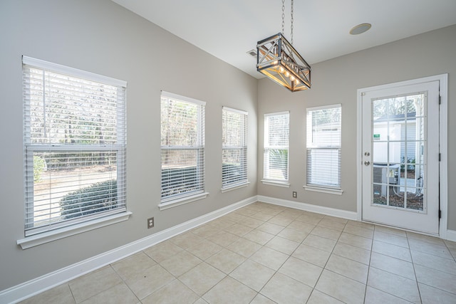 unfurnished dining area featuring baseboards and light tile patterned floors