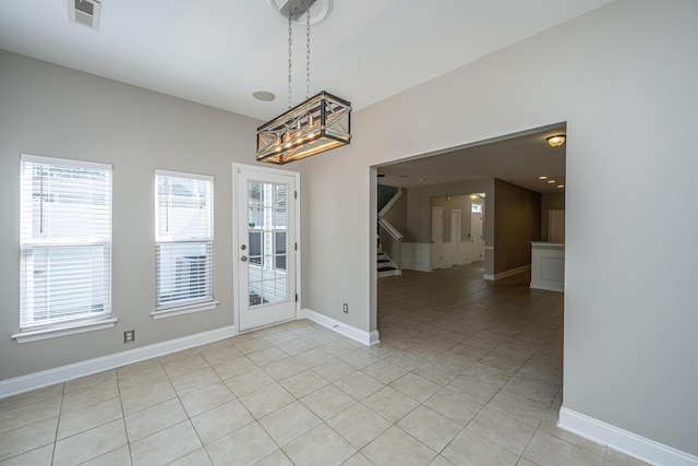 unfurnished dining area featuring stairway, baseboards, visible vents, and light tile patterned flooring