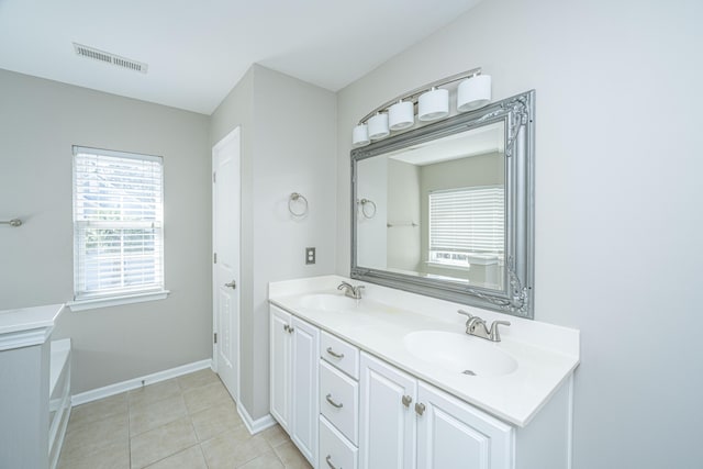 bathroom featuring double vanity, visible vents, a sink, tile patterned flooring, and baseboards