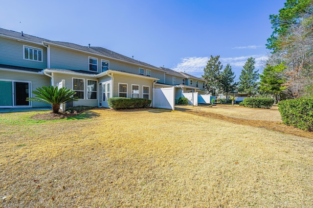 back of house with fence and a yard