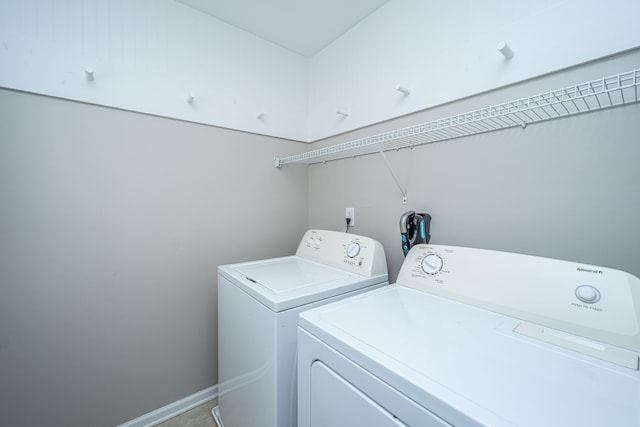 laundry room featuring laundry area, washing machine and dryer, and baseboards