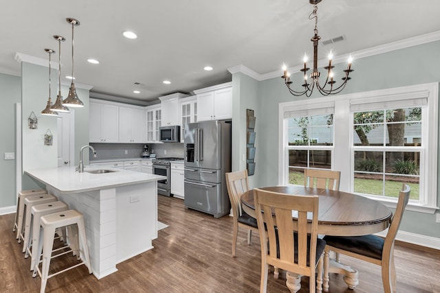 3873 Hanoverian Dr, Mount Pleasant, SC 29429 - kitchen with appliances with stainless steel finishes, a sink, crown molding, glass insert cabinets, and a peninsula