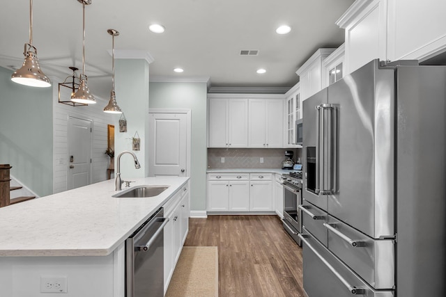 3873 Hanoverian Dr, Mount Pleasant, SC 29429 - kitchen featuring premium appliances, a sink, dark wood-type flooring, crown molding, and glass insert cabinets