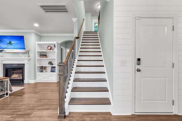 3873 Hanoverian Dr, Mount Pleasant, SC 29429 - stairs featuring ornamental molding, wood finished floors, a glass covered fireplace, recessed lighting, and baseboards