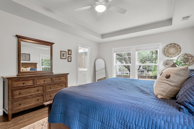 3873 Hanoverian Dr, Mount Pleasant, SC 29429 - bedroom with wood finished floors, a tray ceiling, a ceiling fan, and connected bathroom