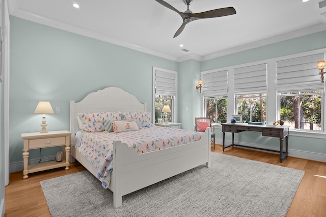 bedroom featuring ceiling fan, recessed lighting, wood finished floors, baseboards, and crown molding