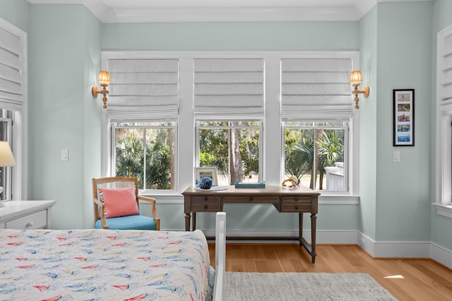 bedroom featuring crown molding, wood finished floors, and baseboards