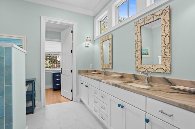 bathroom featuring ornamental molding, a sink, and double vanity