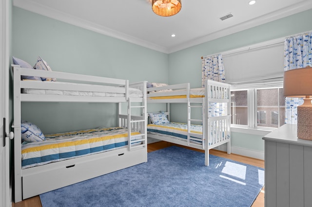 bedroom with recessed lighting, visible vents, ornamental molding, wood finished floors, and baseboards