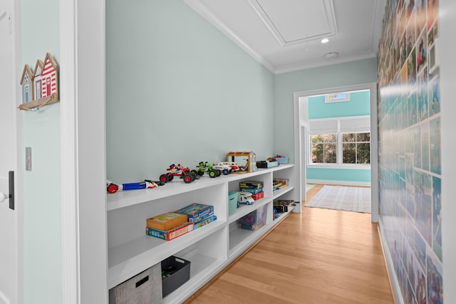 recreation room featuring recessed lighting, wood finished floors, attic access, and crown molding