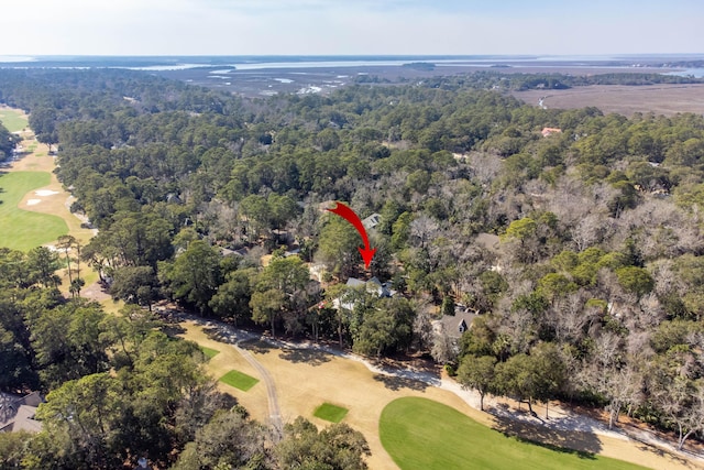 birds eye view of property with view of golf course and a forest view