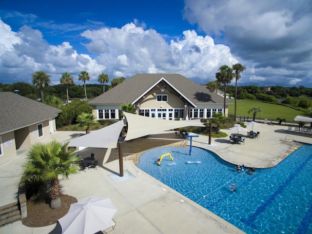 community pool with a patio and fence