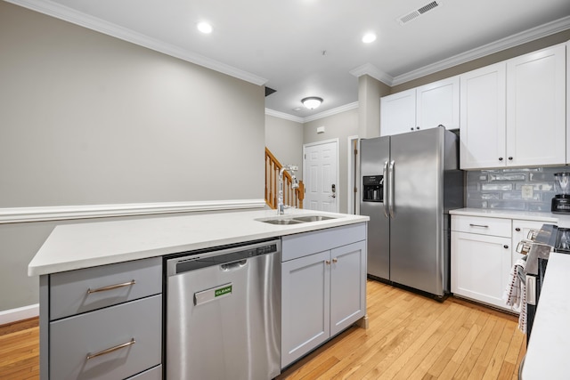 81 Sandbar Ln Unit 23, Folly Beach, SC 29439 - kitchen featuring stainless steel appliances, light wood-type flooring, crown molding, light countertops, and tasteful backsplash