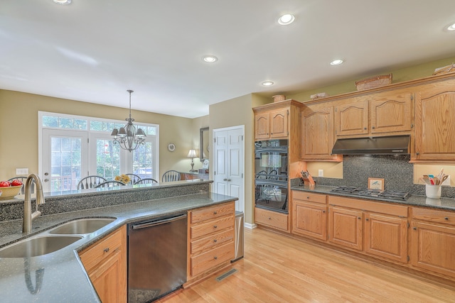 kitchen featuring sink, pendant lighting, an inviting chandelier, light wood-type flooring, and appliances with stainless steel finishes