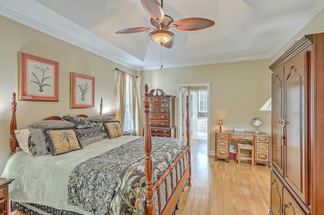 bedroom with ornamental molding, a tray ceiling, light wood-type flooring, and ceiling fan