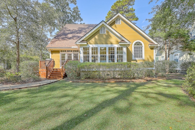 rear view of property with a yard and a wooden deck