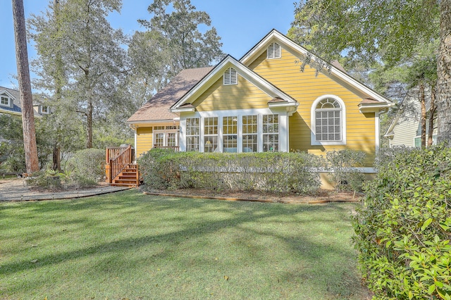 view of front of home with a front yard and a deck