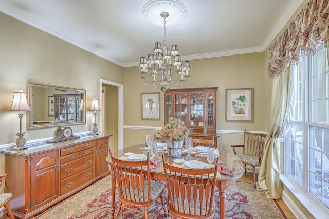 dining room with light hardwood / wood-style floors, crown molding, and an inviting chandelier