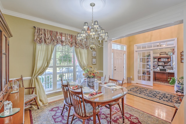 dining room featuring ornamental molding, a notable chandelier, and hardwood / wood-style floors