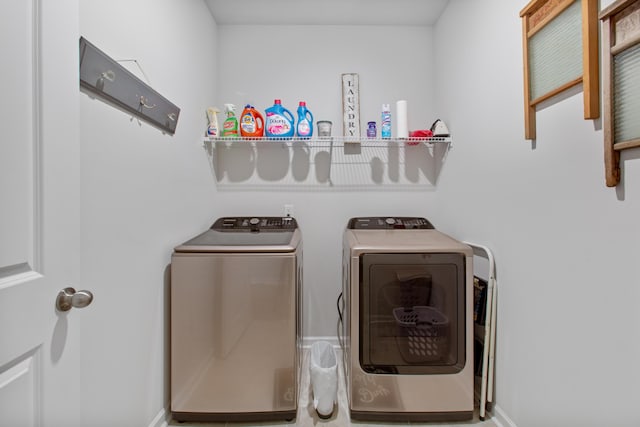 washroom with washer and dryer and baseboards