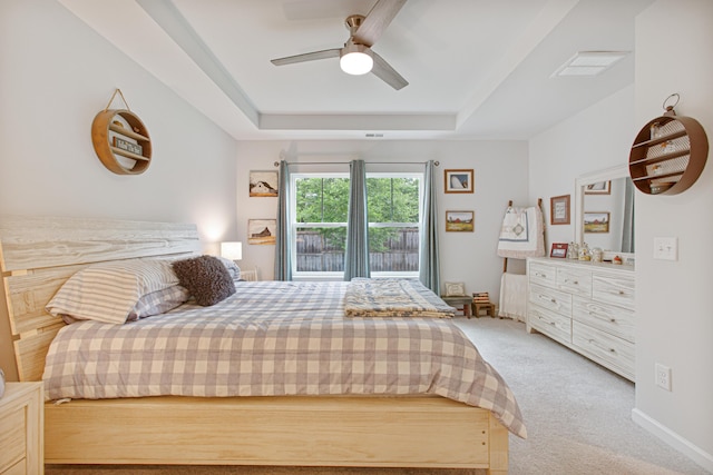 bedroom featuring carpet, a raised ceiling, and ceiling fan