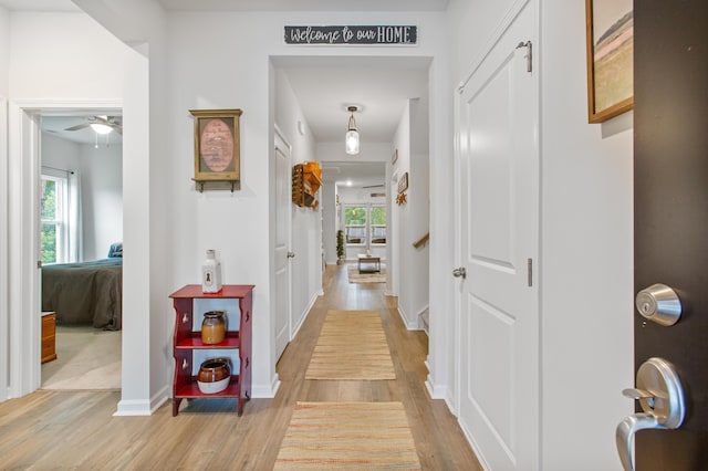 hallway with light wood-style floors and baseboards