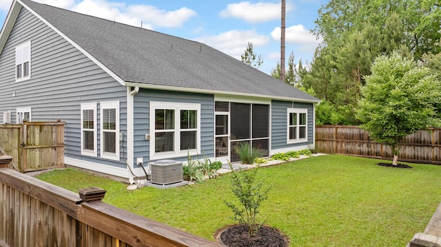 back of house featuring central AC, roof with shingles, and a sunroom
