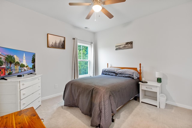 bedroom featuring light carpet, baseboards, and ceiling fan