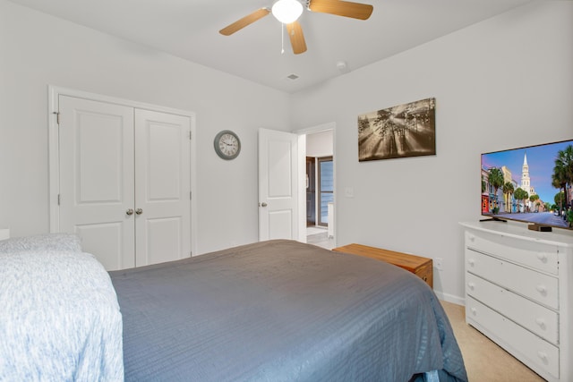 bedroom with light colored carpet, a ceiling fan, and a closet