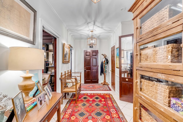 tiled entrance foyer with a notable chandelier and crown molding