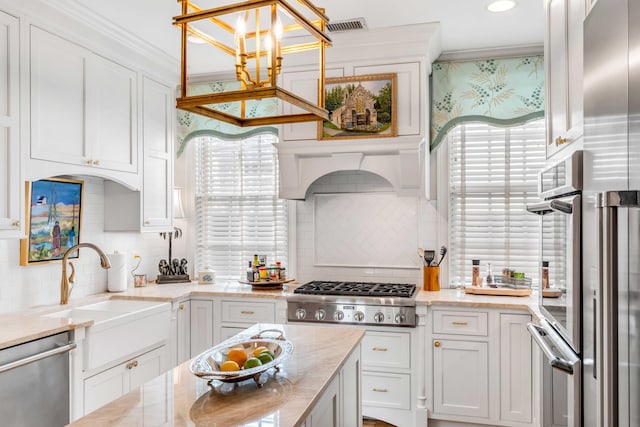 kitchen featuring backsplash, white cabinetry, pendant lighting, and stainless steel appliances