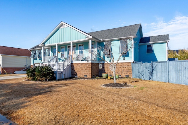 view of front of house with a front yard and covered porch