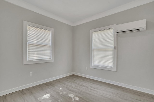 unfurnished bedroom featuring light hardwood / wood-style floors, crown molding, and a wall mounted AC