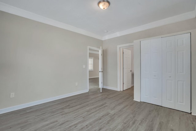 unfurnished bedroom featuring ornamental molding, a closet, and light hardwood / wood-style floors