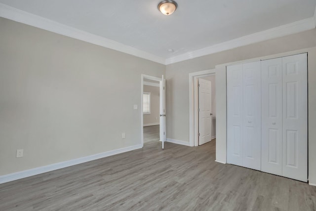 1910 Kerry St, North Charleston, SC 29406 - unfurnished bedroom with light wood-type flooring, crown molding, baseboards, and a closet
