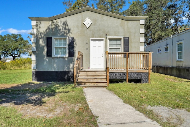 view of front facade with a front lawn and a deck