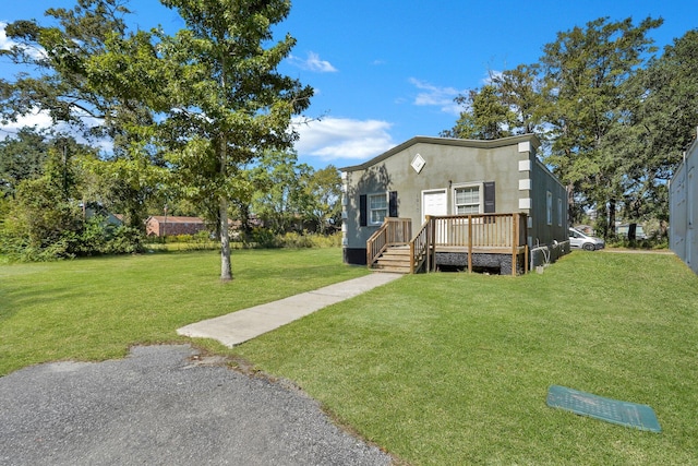 view of front of property featuring a front yard and a wooden deck